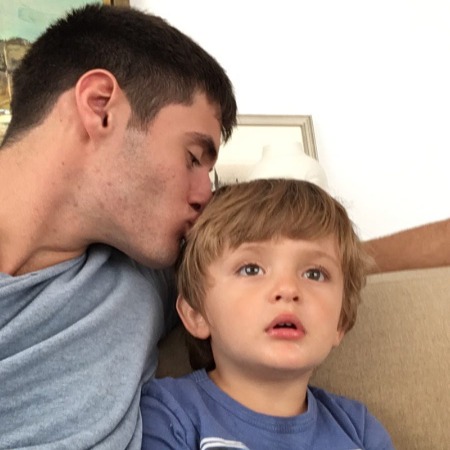 Oliver Mustafa Oz kissing his nephew on the cheek